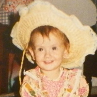 Foto de Juliana Tozzi na infância. Ela sorri para a foto e usa chapéu e roupas de festa junina.