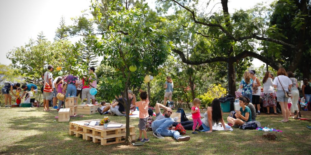 foto de Piquenique organizado pelo Movimento Boa Praça, com várias pessoas conversando, sentadas no gramado e fazendo atividades variadas na praça Amadeu Decome, em São Paulo.