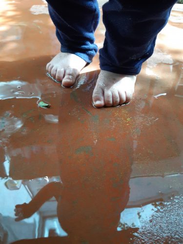 Descrição da imagem: pés de um bebê no chão molhado.