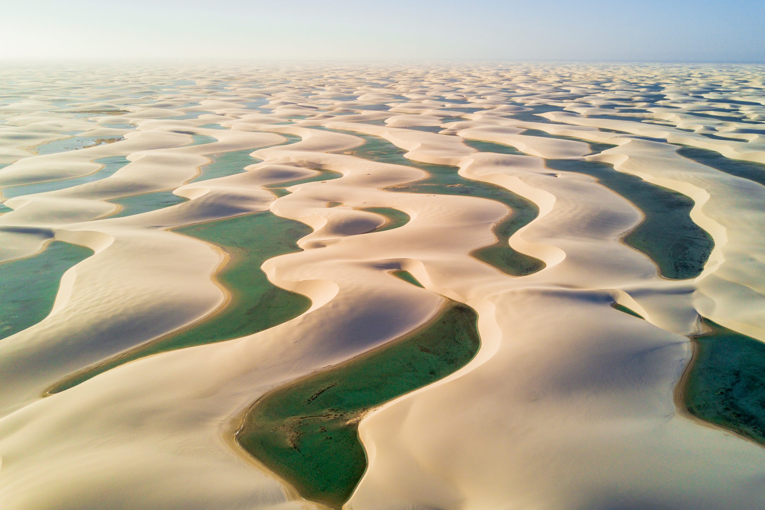 Foto de dunas com pequenas lagoas entre elas no Parque Nacional dos Lençóis Maranhenses.
