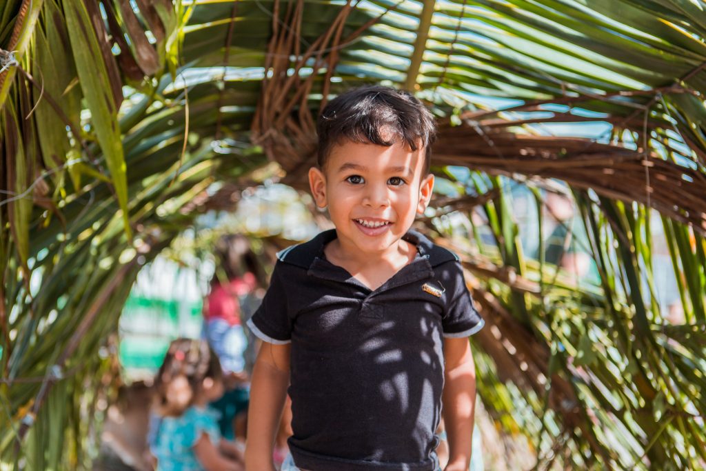 [:pt]Criança sorrindo embaixo de um túnel feito com folhas. Parque Naturalizado em Caruaru.[:]