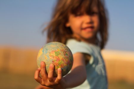 Criança segurando um globo terrestre. Crise do clima