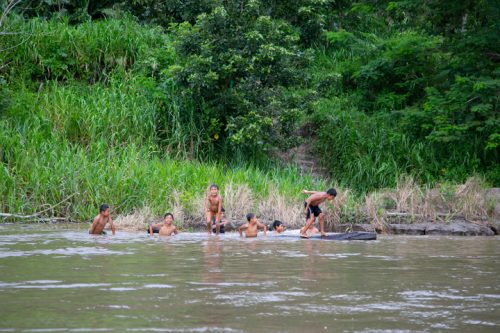 Crianças brincam na beira de um rio, na Amazônia